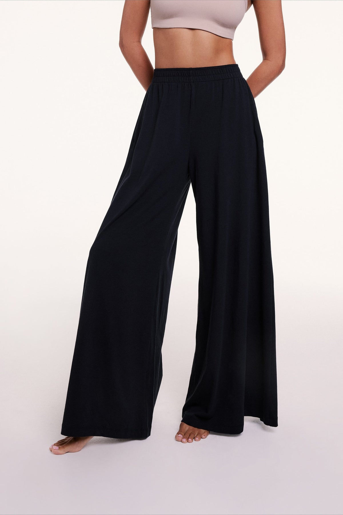 In a studio setting, Courtney wears the Sunday Pima Pant in Black, highlighting the elastic waistband and fluid, wide-leg silhouette.