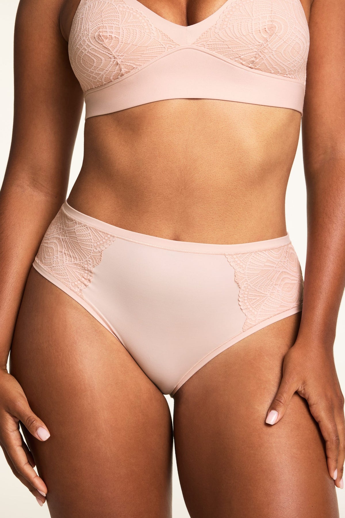 On a light studio backdrop, Amber wears the Bliss Lace Bralette and Bliss Lace Highwaist Brief in Ember Rose, with the lace-trimmed V-neck bralette and high-waisted brief shown from the front. sizing: Amber wears size Medium