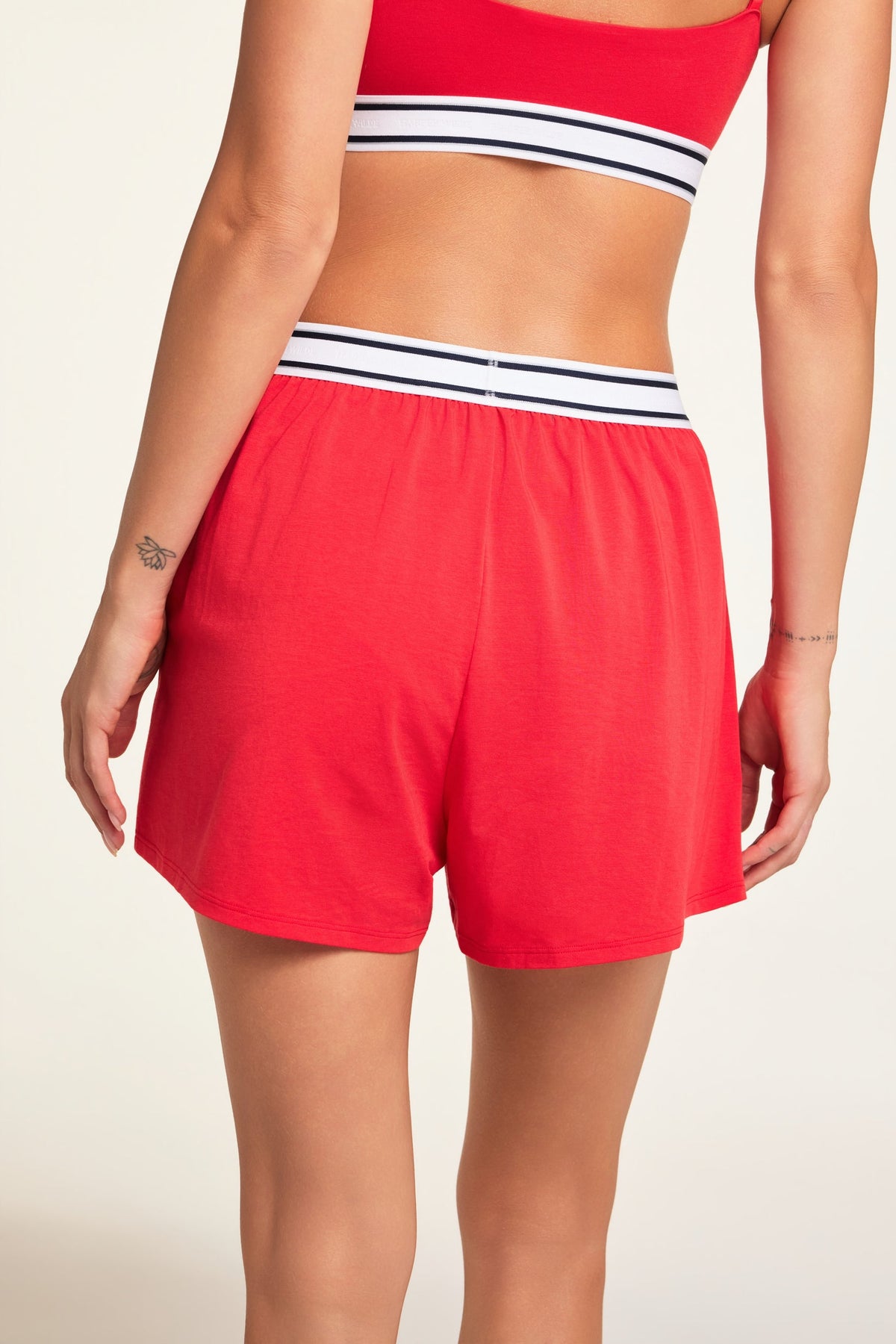 Three-quarter back view of the Cloud Cotton Short in Cherry paired with the Cloud Cotton Bandeau Bralette in Cherry.