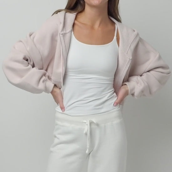Video of a model wearing the Bliss Cami in White layered under different outfits - Jeans and Chambray shirt, white trousers and white sweatpants with a gray hoodie.
